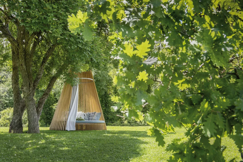Photo d'un bed de la marque Ethimo dans un jardin