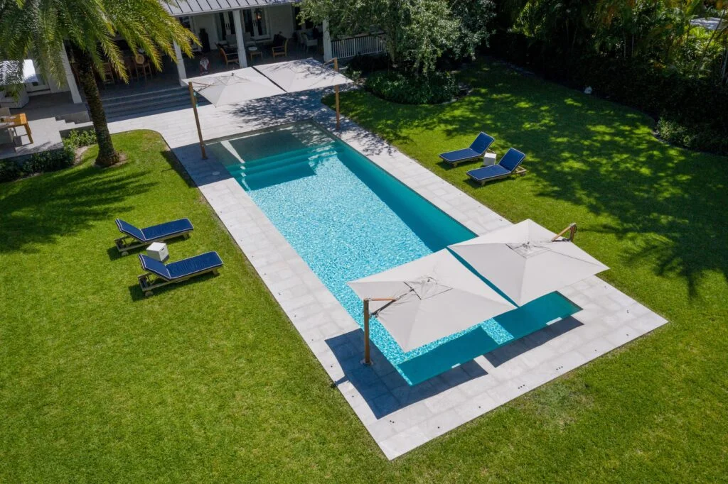 photo d'un jardin avec piscine et des parasols Tucci