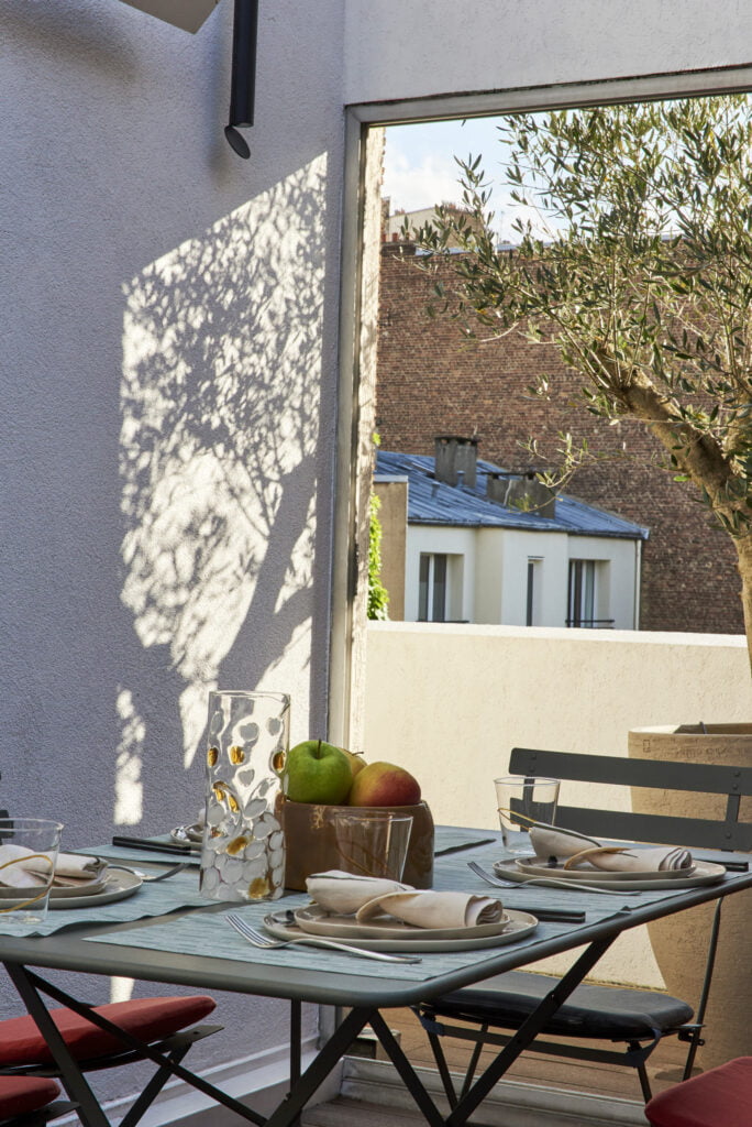 photo d'une terrasse dans l'esprit terracotta avec du mobilier d'extérieur et un olivier dans un grand pot Atlier Vierkant