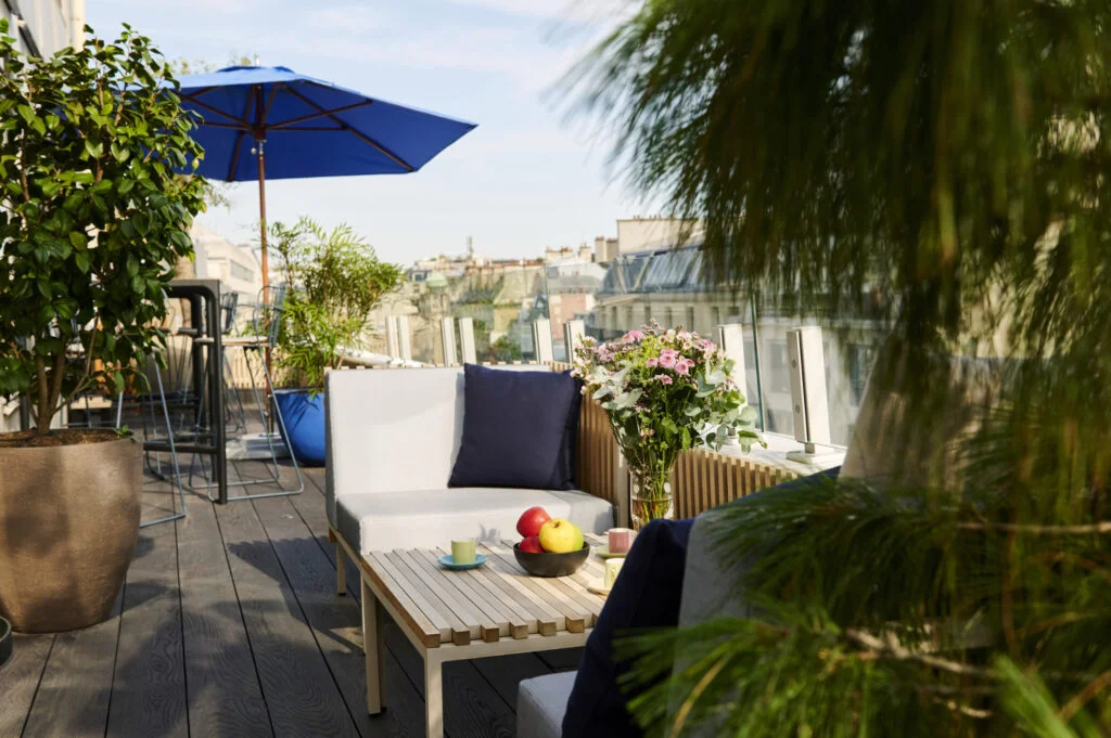 Terrasse en bois avec du mobilier d'extérieur chez Ego Paris et parasol Tucci et pots Atelier Vierkant et Domani, partenaires de Terrasse et Jardin de Paris