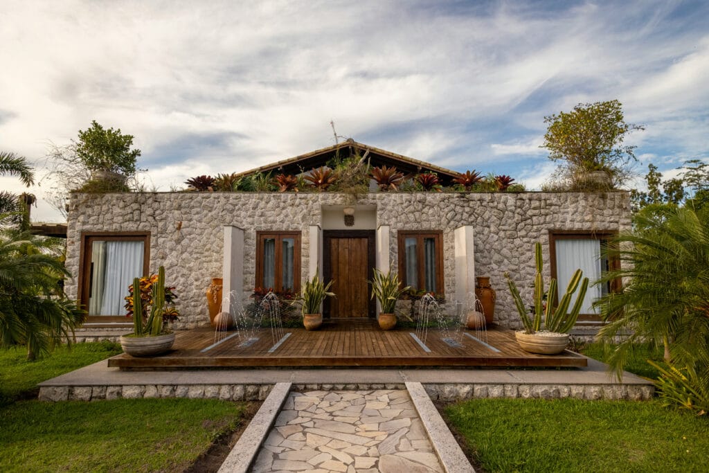 Maison en pierre de style méditerranéen avec une terrasse en bois surélevée équipée de trois jets d'eau Deckflow