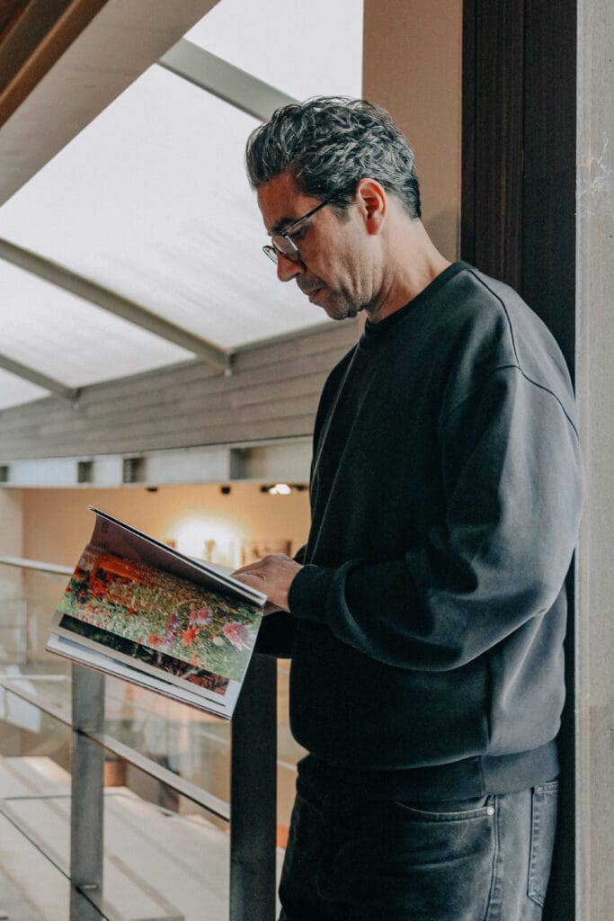 Compositeur végétal consultant un ouvrage de références botaniques dans son bureau d'études.