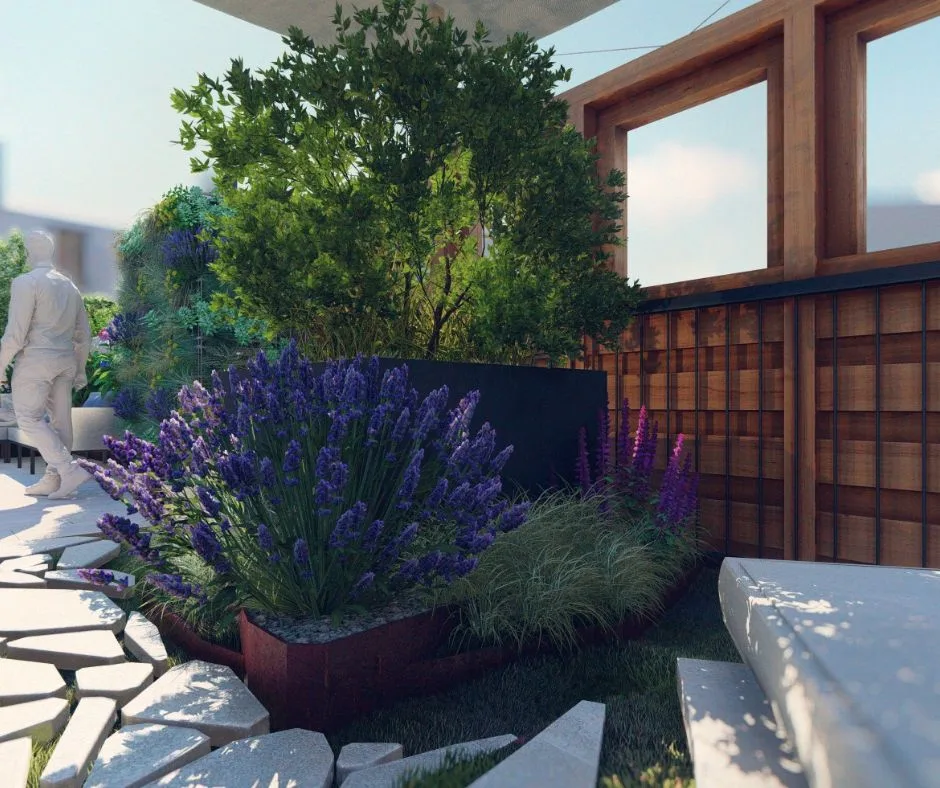 Jardinière en acier thermolaqué accueillant des lavandes et des graminées devant une clôture en bois