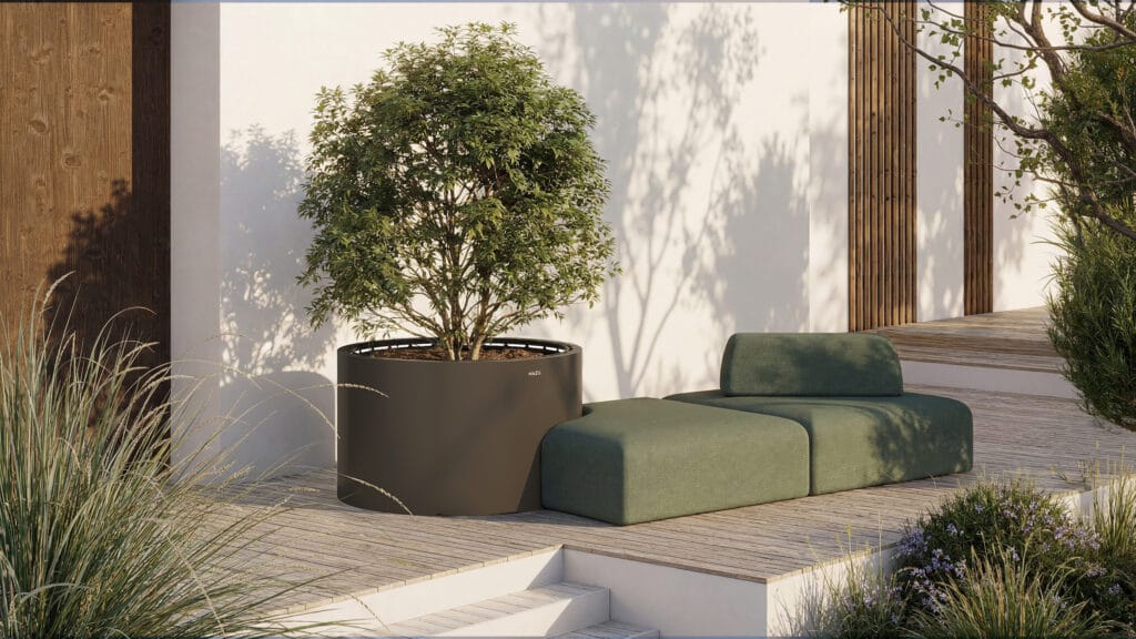 Jardinière design haut de gamme Mazu de forme cylindrique avec arbuste sur terrasse en bois.