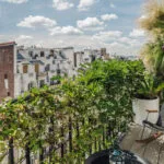 Aménagement balcon Paris - floraisons printanières avec vue sur toits parisiens
