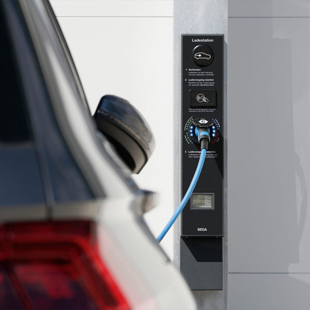 Module de recharge Bega mural pour véhicule électrique avec câble type 2 branché, interface RFID et indicateurs LED, fixé sur pilier en béton