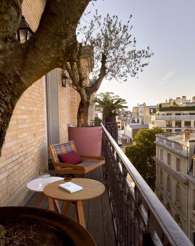 Coin salon extérieur sur un balcon parisien luxueux entouré de plantes
