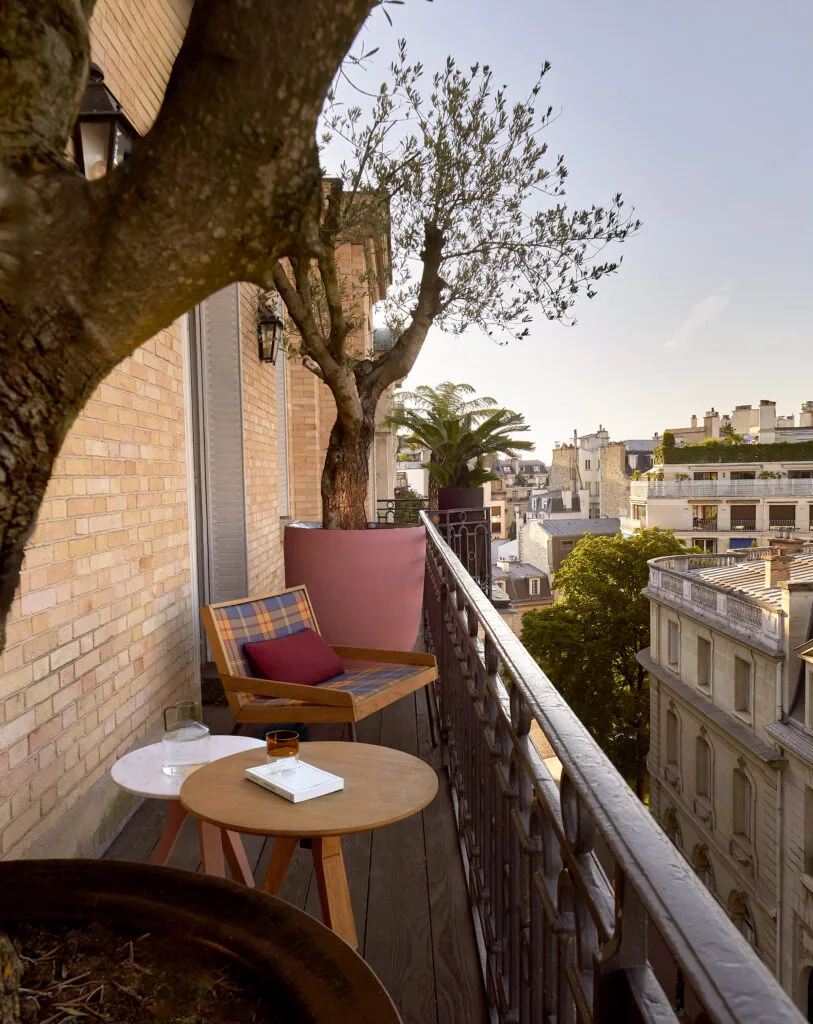 Coin salon extérieur sur un balcon parisien luxueux entouré de plantes