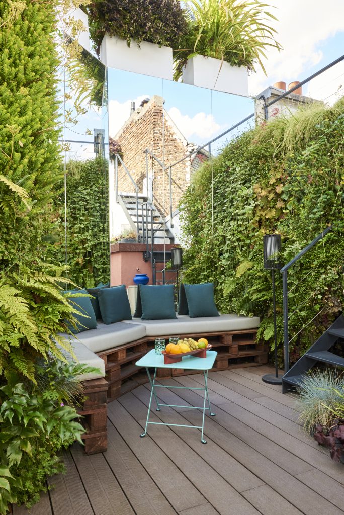 Terrasse parisienne en platelage bois bordée de plantations entretenues