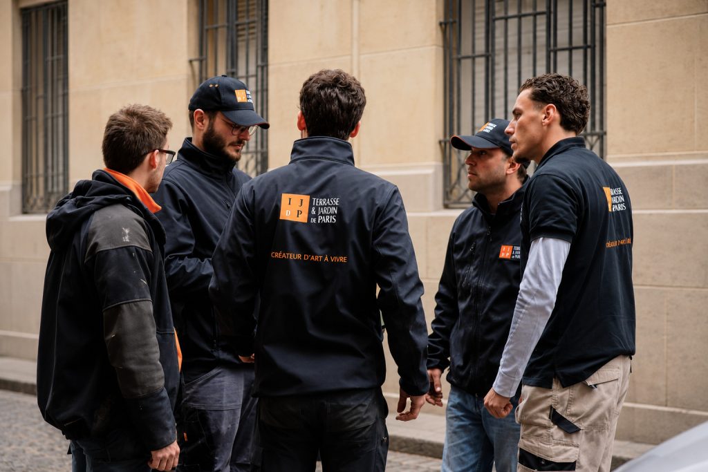 Jardiniers de l'équipe entretien échangeant avant une intervention dans un jardin parisien