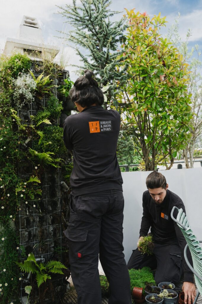 Jardiniers entretenant les plantations d'un jardin parisien avec des outils manuels
